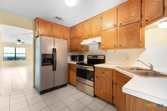 a kitchen with stainless steel appliances a refrigerator sink and cabinets