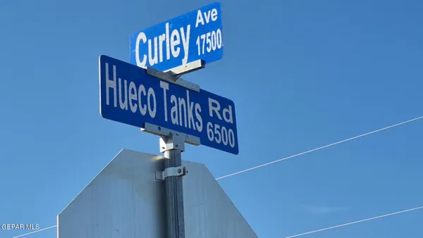 a view of a sign board with large trees