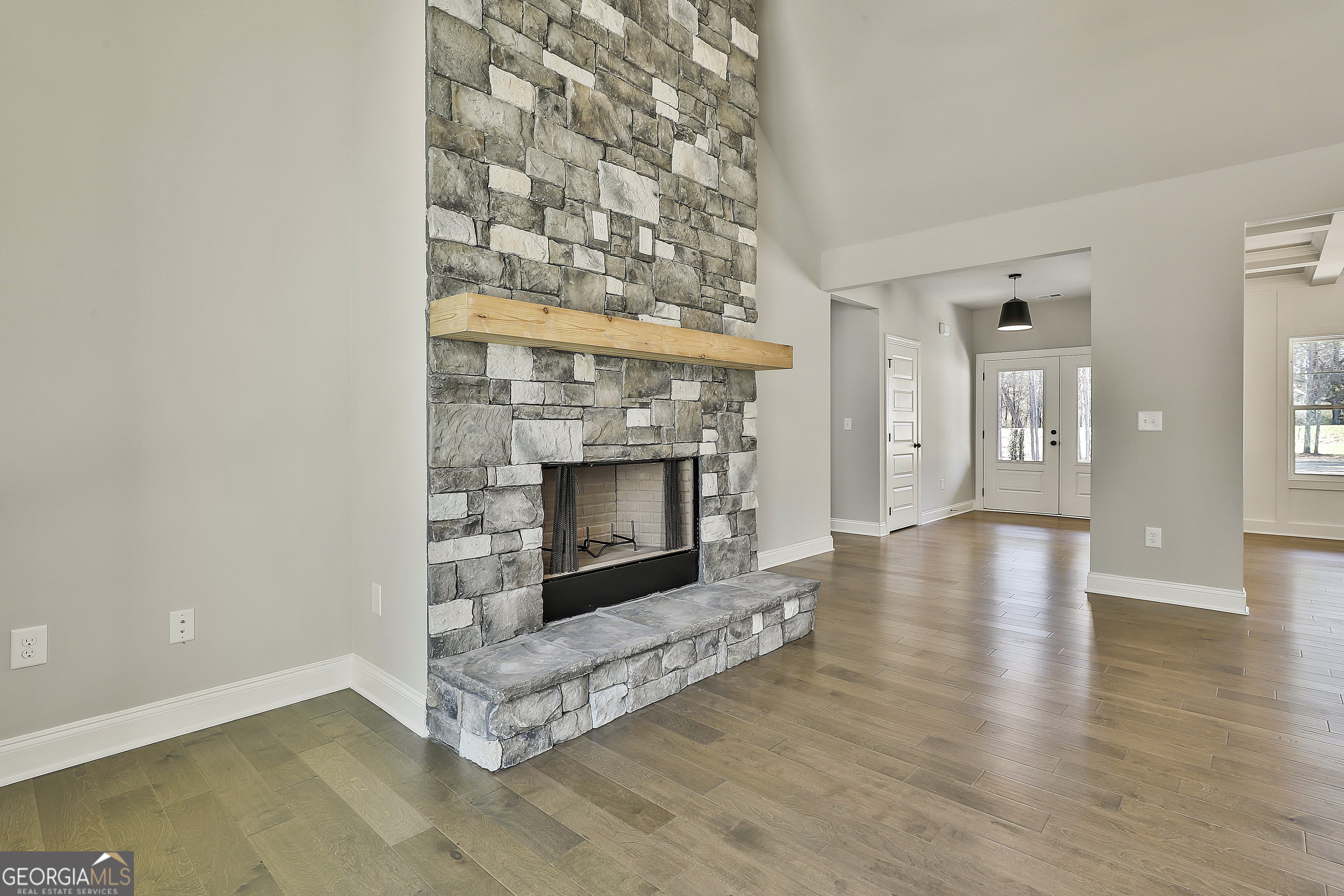 837 Alex Stephens Road Moreland, GA 30259 - Photo 16 of 50 an empty room with wooden floor and fireplace