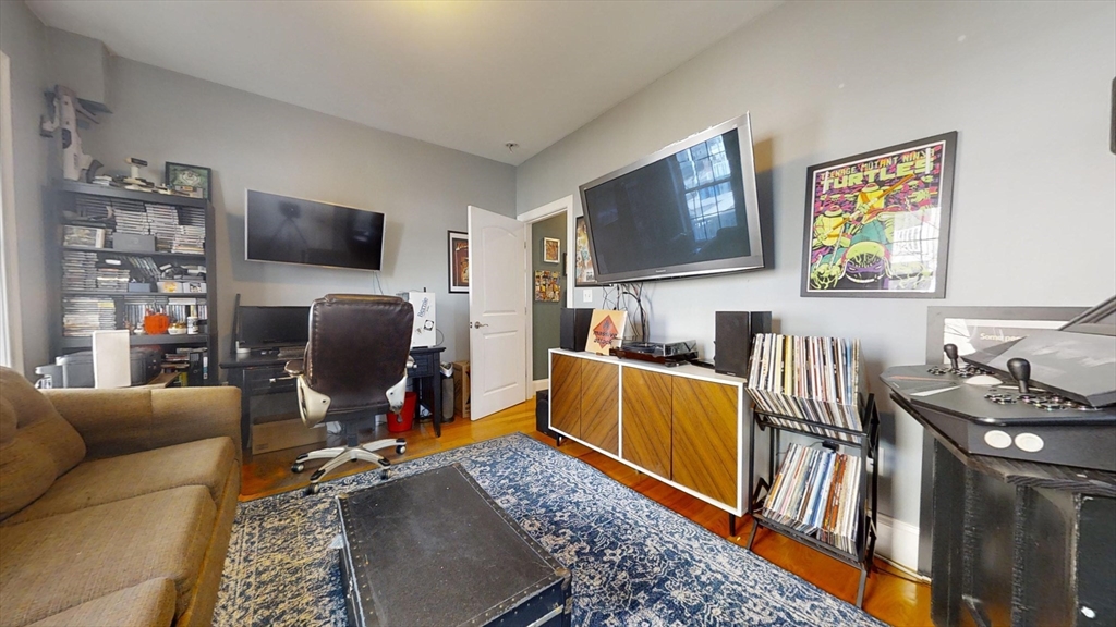 42 Olney Street, Unit 1R Boston, MA 02121 - Photo 13 of 21 a living room with furniture a flat screen tv and kitchen view