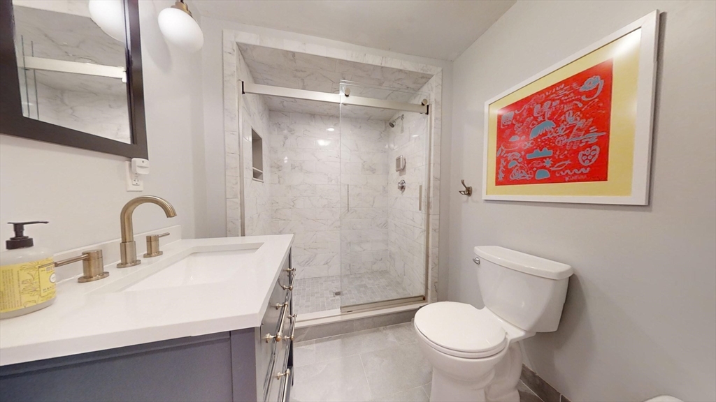 42 Olney Street, Unit 1R Boston, MA 02121 - Photo 14 of 21 a bathroom with a toilet sink and mirror
