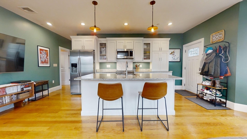 42 Olney Street, Unit 1R Boston, MA 02121 - Photo 5 of 21 a kitchen with stainless steel appliances granite countertop a stove and a refrigerator