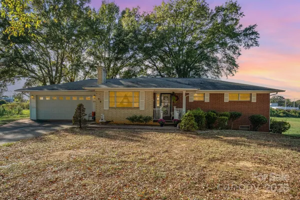 a view of a house with backyard and trees