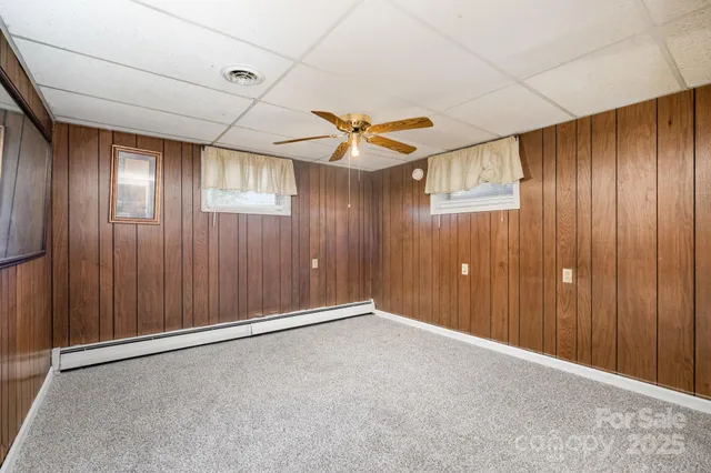 an empty room with ceiling fan and window