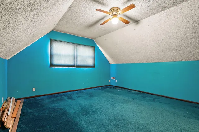 a view of an empty room with a window and a ceiling fan