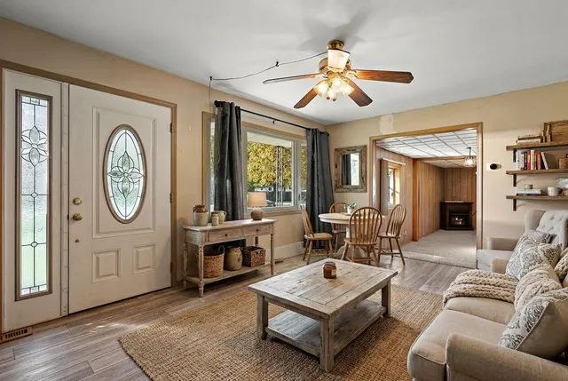 a living room with furniture a large window and a clock
