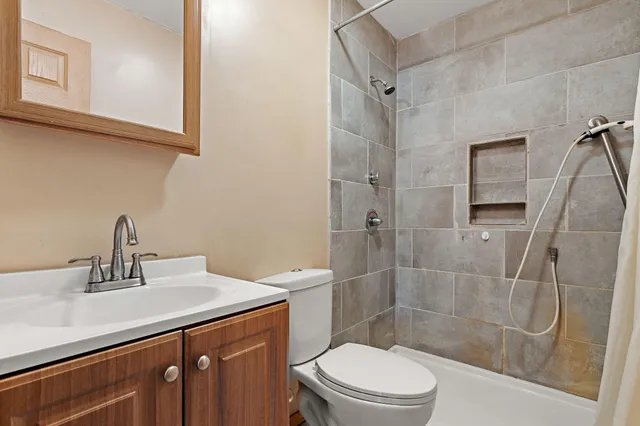 a bathroom with a sink a toilet and shower