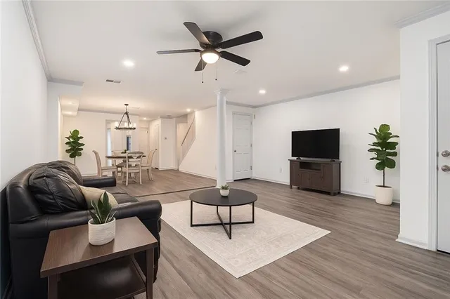 a living room with furniture and a wooden floor