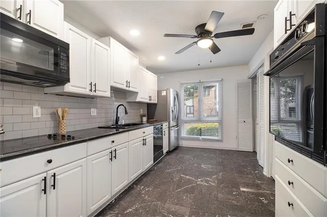a kitchen with granite countertop a sink stainless steel appliances and cabinets