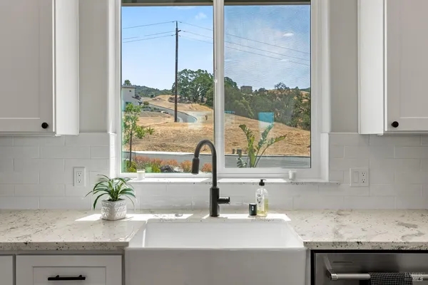 a kitchen with stainless steel appliances a stove a sink and white cabinets