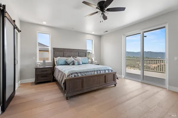 a bedroom with a large bed and wooden floor
