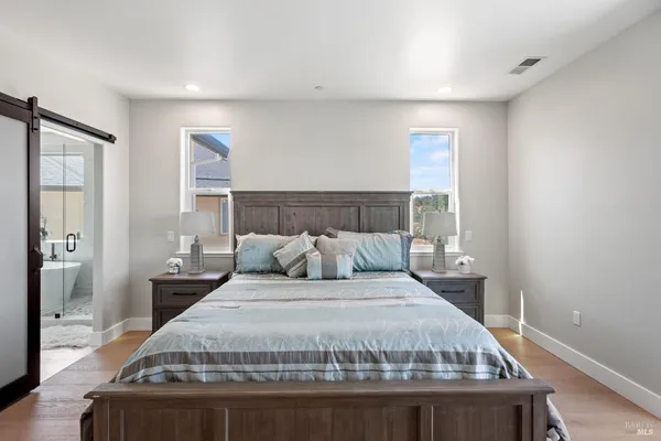a bedroom with a bed a dresser and a chandelier