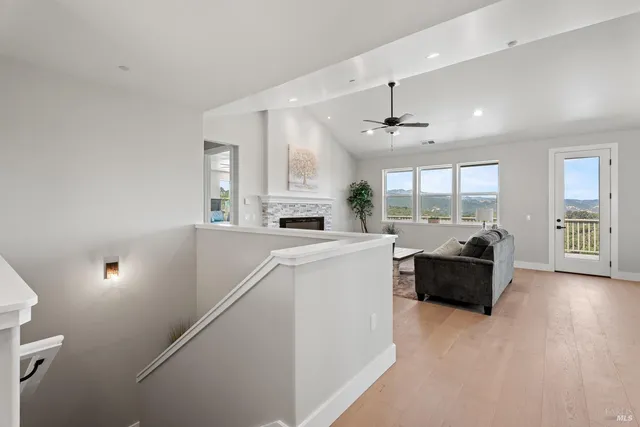 a living room with furniture and a large window with garden view