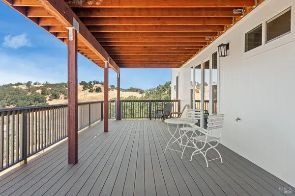 a balcony with chairs and wooden floor