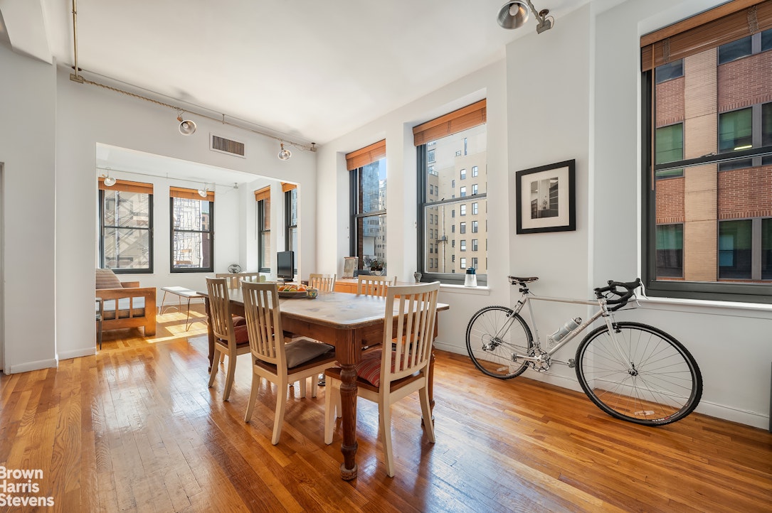 a view of a a dining room with furniture window and wooden floor