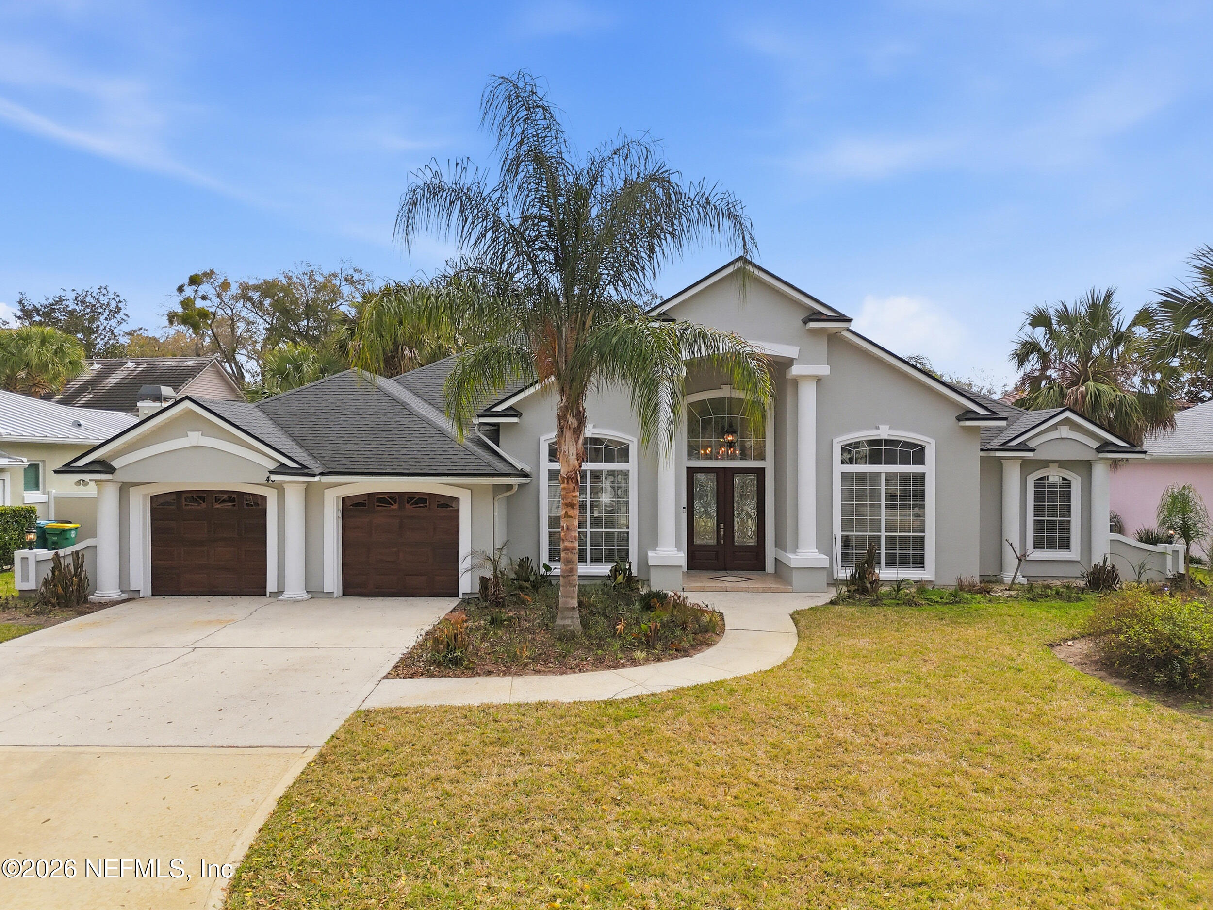a front view of a house with a yard and trees