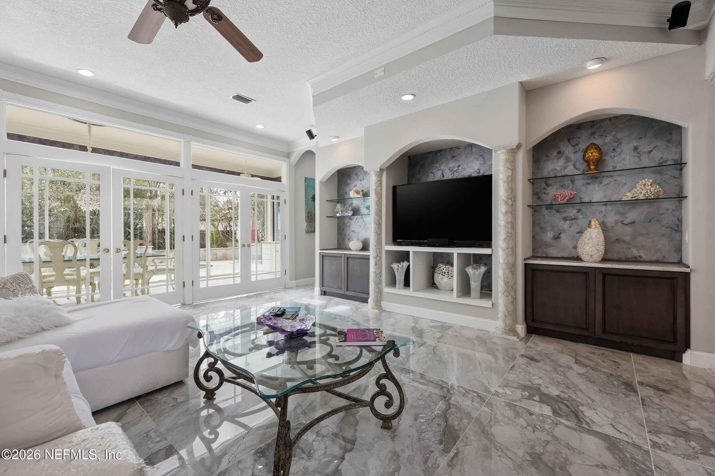 40 Tallwood Road Jacksonville Beach, FL 32250 - Photo 13 of 75 a living room with furniture a flat screen tv and a floor to ceiling window