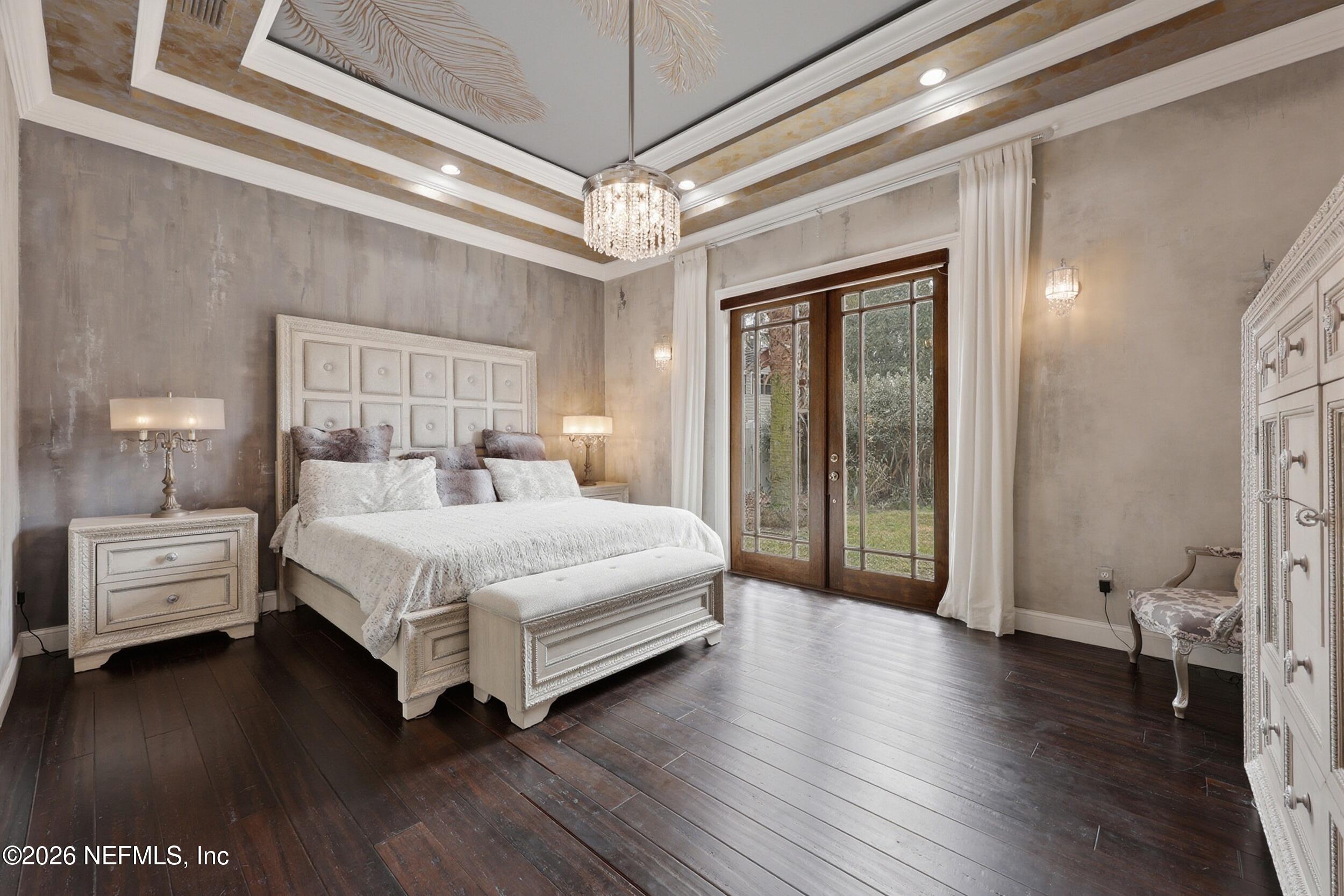 40 Tallwood Road Jacksonville Beach, FL 32250 - Photo 34 of 75 a bedroom with a large bed and a chandelier