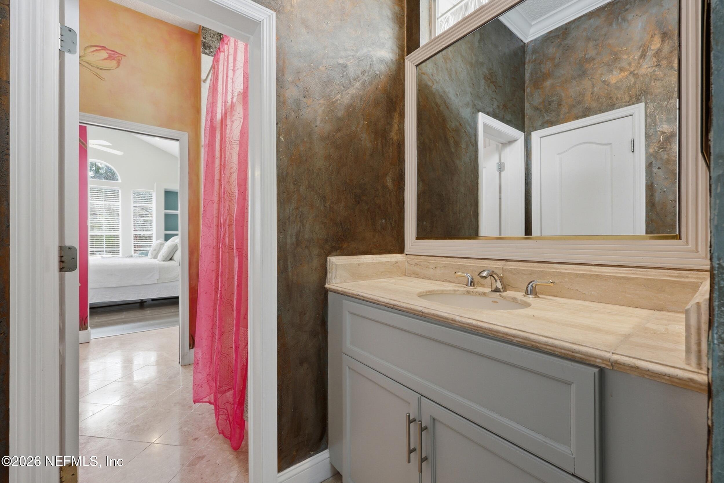 40 Tallwood Road Jacksonville Beach, FL 32250 - Photo 45 of 75 a en suite bathroom with a granite countertop sink and a mirror
