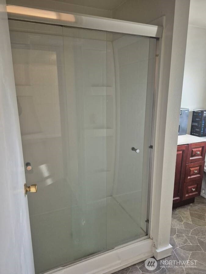 317 7th Street Southwest, Unit 3 Puyallup, WA 98371 - Photo 4 of 6 a bathroom with a glass shower door