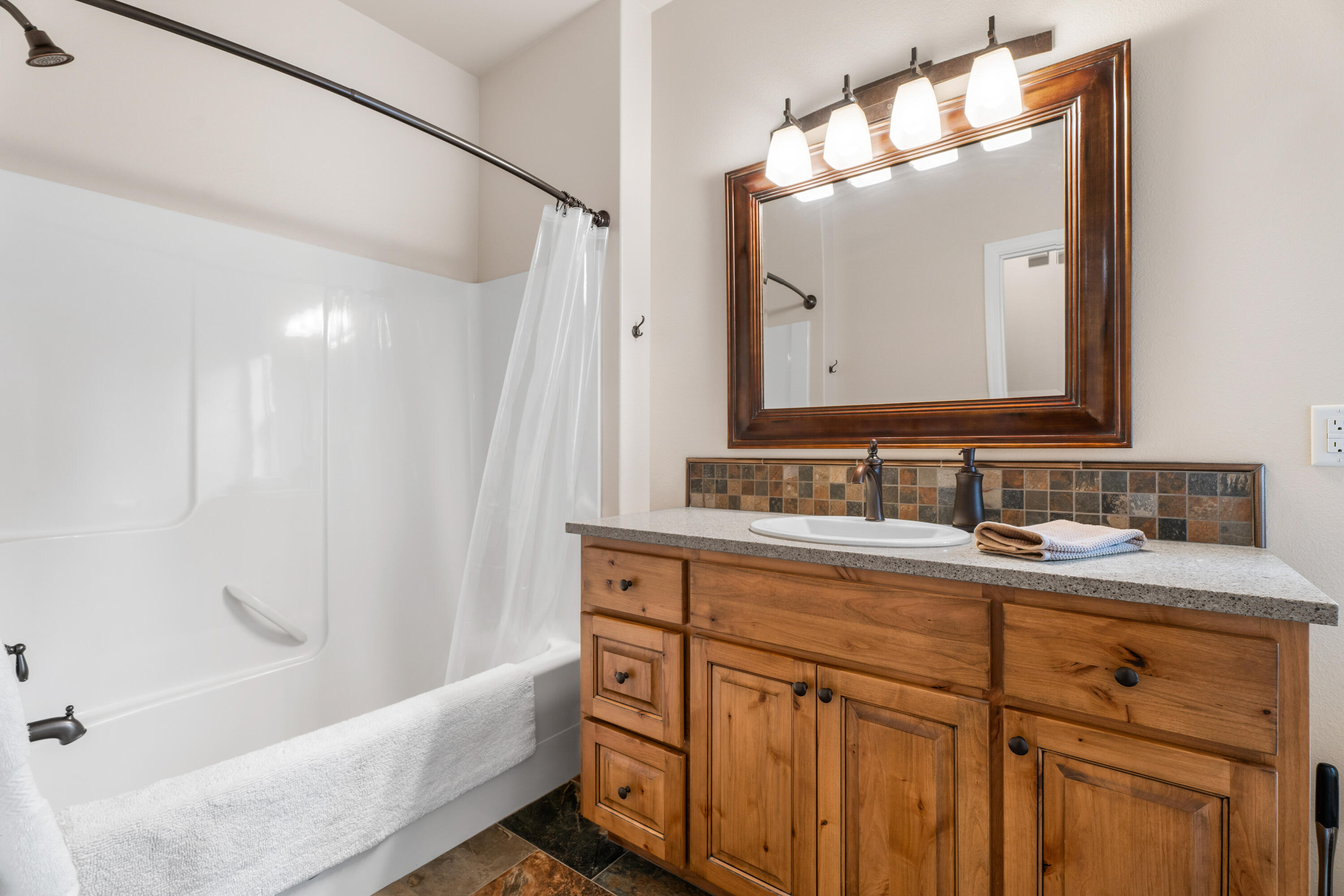 205 Vista Rim Drive Redmond, OR 97756 - Photo 22 of 85 a bathroom with a granite countertop sink mirror and a bathtub