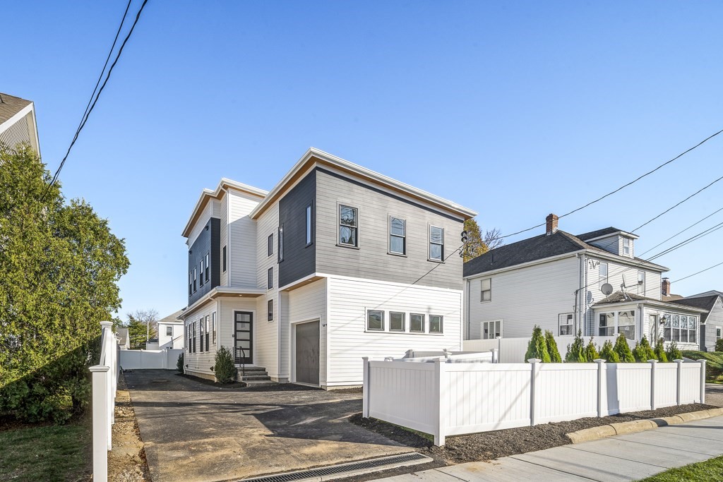 a view of a white building among the street with palm trees