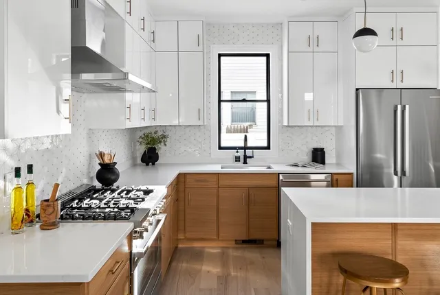 a kitchen with stainless steel appliances a sink a stove a refrigerator cabinets and a counter top space