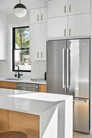 a kitchen with stainless steel appliances granite countertop a refrigerator and a sink