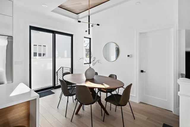 a dining room with furniture a chandelier and wooden floor