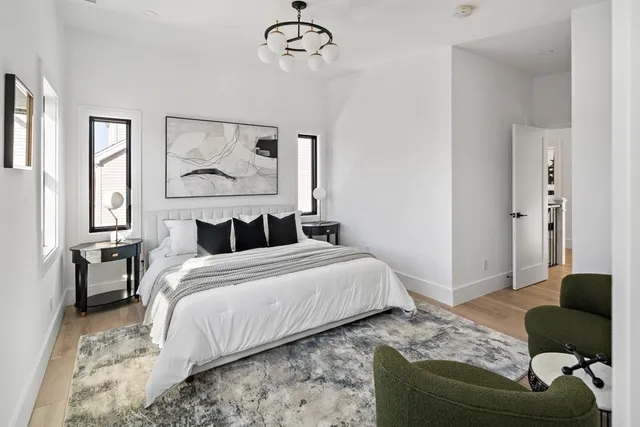 a bedroom with a bed couches chair and a window