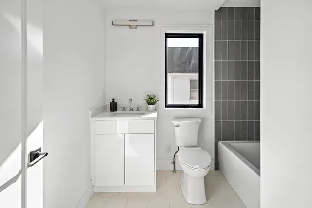 a bathroom with a toilet a sink and a mirror