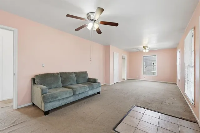 a living room with furniture and a ceiling fan