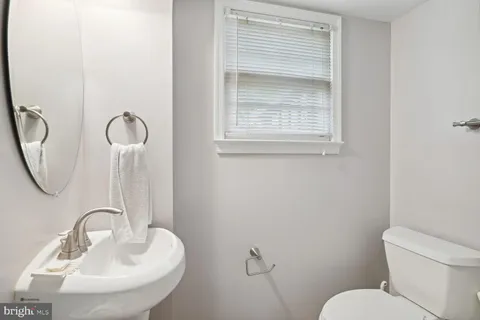 a bathroom with a toilet sink and mirror