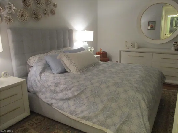 a large bed sitting in a bedroom next to a bathroom mirror