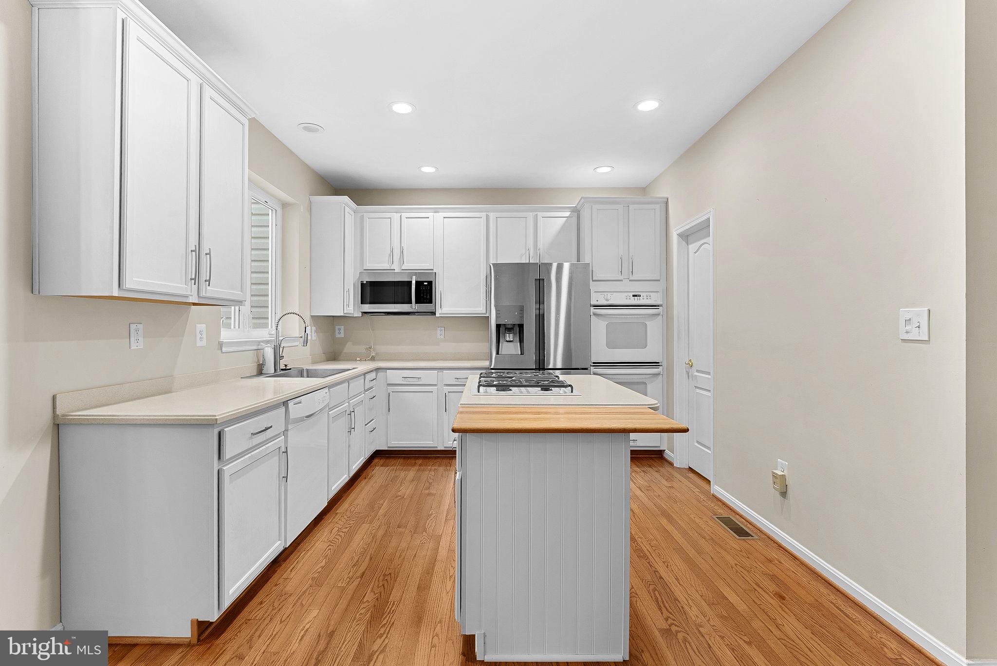 13574 Big Boulder Road Herndon, VA 20171 - Photo 11 of 45 a kitchen with white cabinets sink and stove