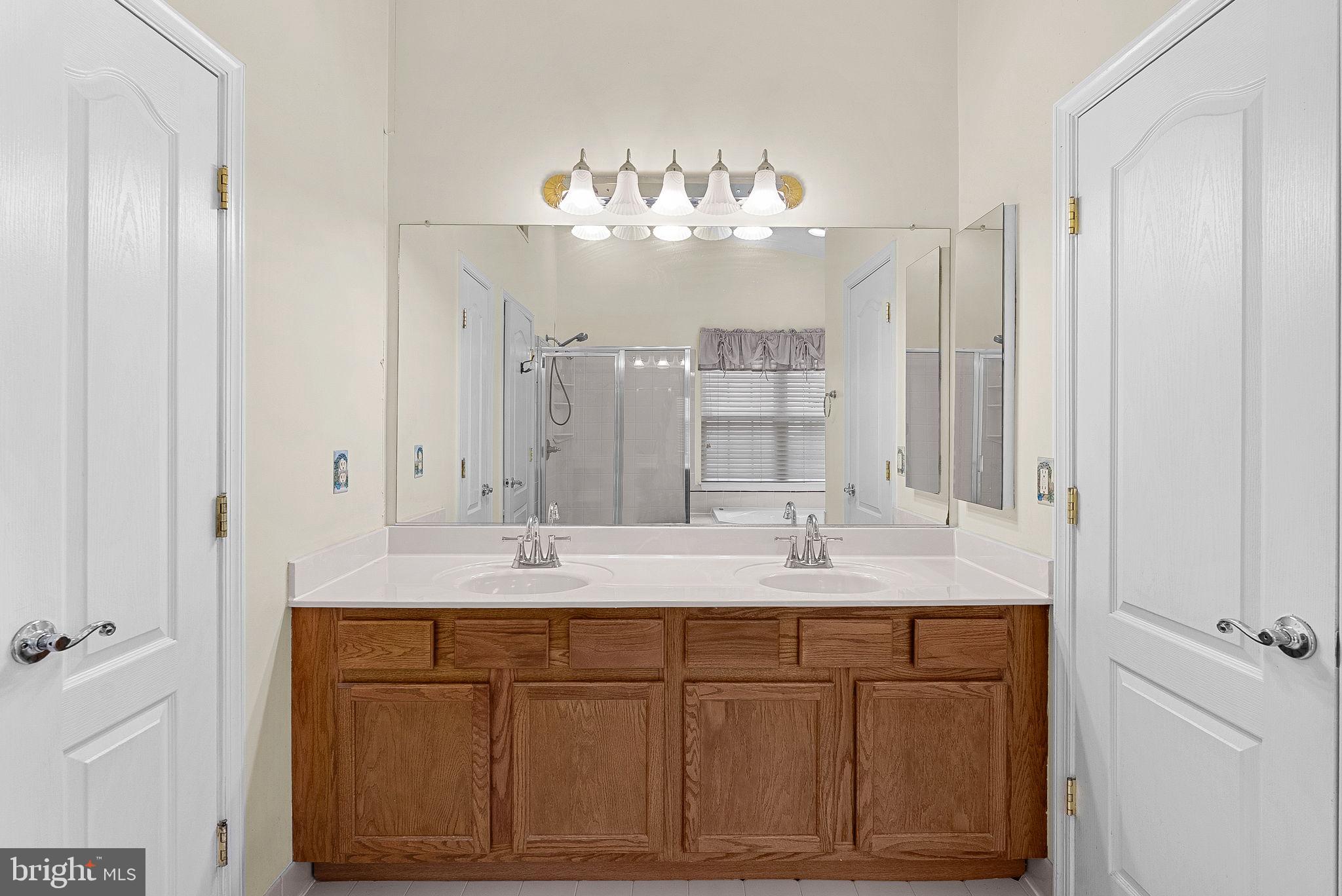 13574 Big Boulder Road Herndon, VA 20171 - Photo 32 of 45 a bathroom with a double vanity sink and mirror