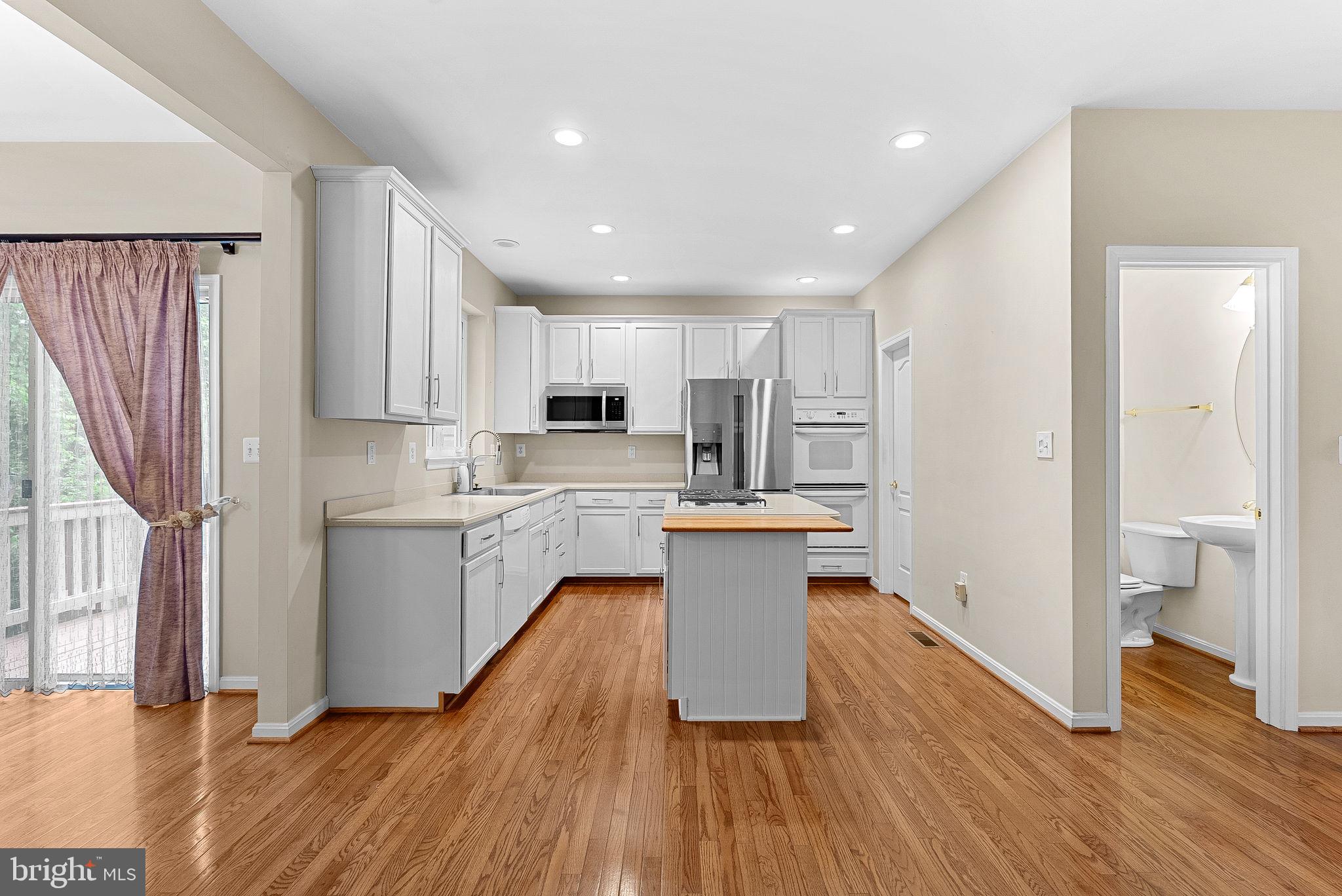 13574 Big Boulder Road Herndon, VA 20171 - Photo 10 of 45 a kitchen with white cabinets and white appliances