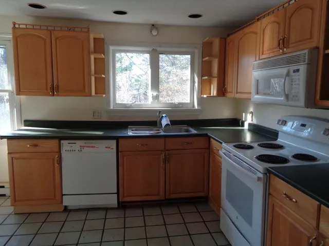 a kitchen with granite countertop a sink stove and cabinets