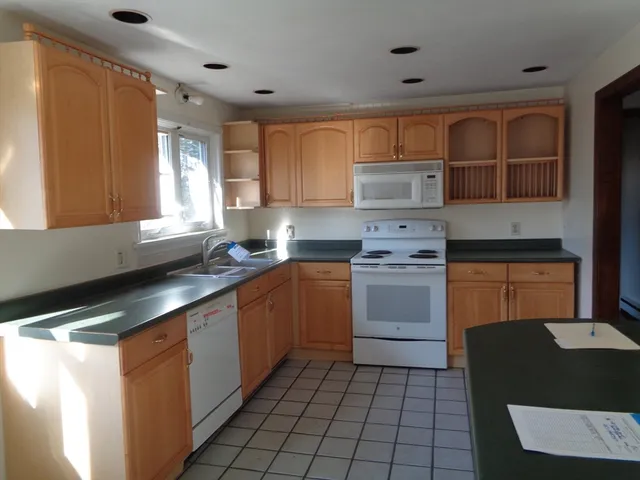 a kitchen with a stove sink and cabinets