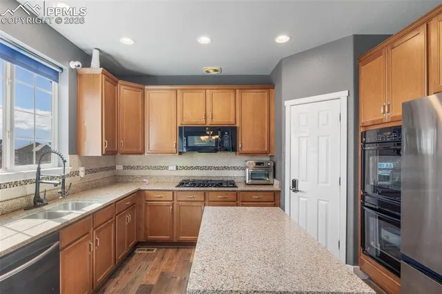 a kitchen with stainless steel appliances granite countertop refrigerator sink and cabinets