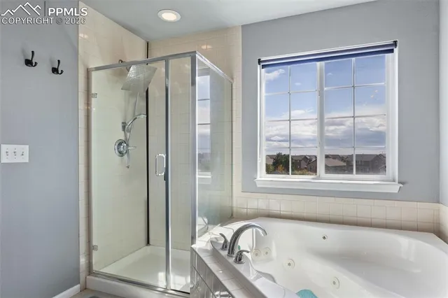 a bathroom with a tub a sink and a window