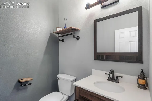 a bathroom with a sink mirror and toilet