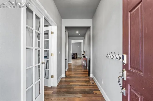 a view of a hallway with wooden floor and staircase