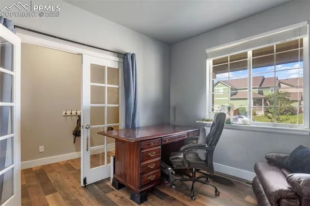 a view of a workspace with furniture and a window