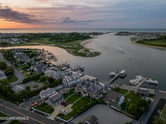 an aerial view of ocean and residential houses with outdoor space