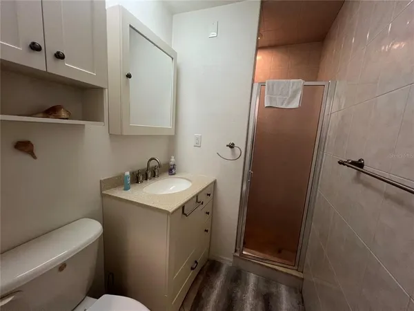 a bathroom with a granite countertop sink toilet and shower