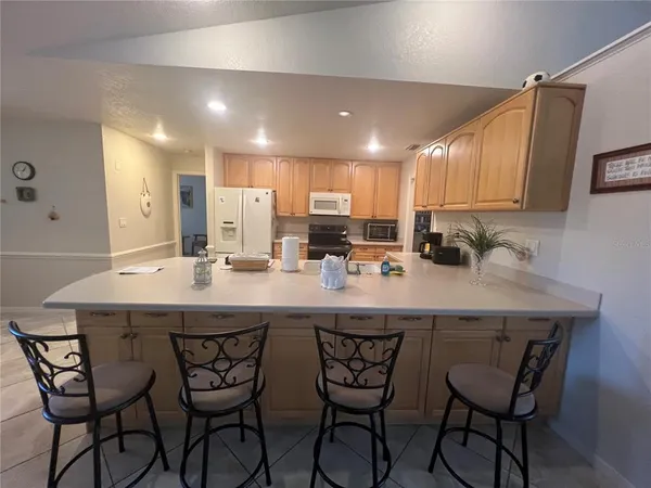a kitchen with a sink and chairs