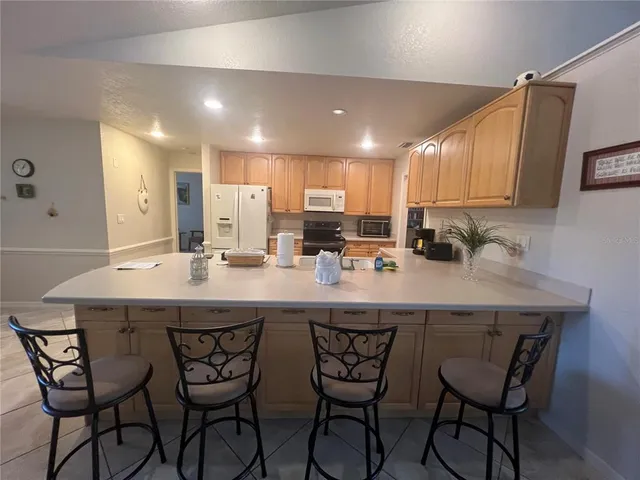 a kitchen with a sink and chairs