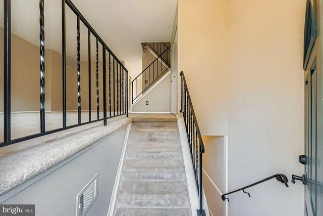 a view of staircase with white walls and a window