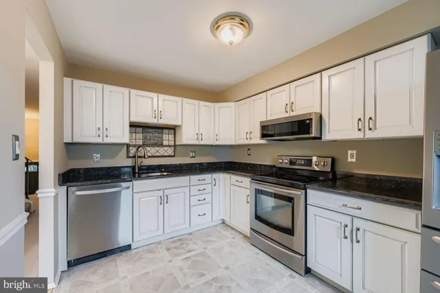 a kitchen with stainless steel appliances a stove a sink and a microwave